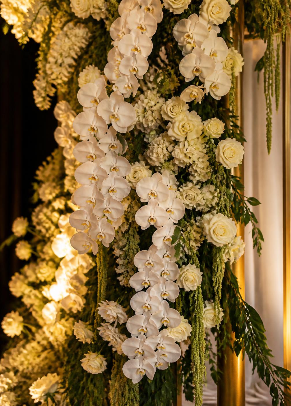 Close up of cascading orchid and rose floral installation